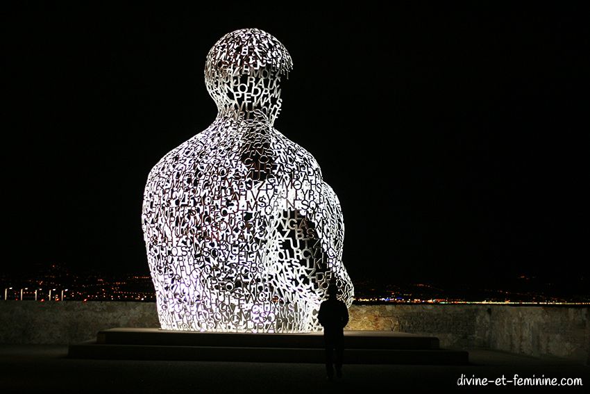 Statue Nomade de Jaume Plensa sur le port d'Antibes éclairée la nuit.